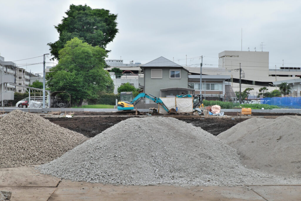 市街地の造成現場に積まれた砕石と重機